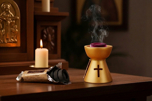 Open roll of quick-light charcoal discs on a wood altar, one disc lit over a candle flame 