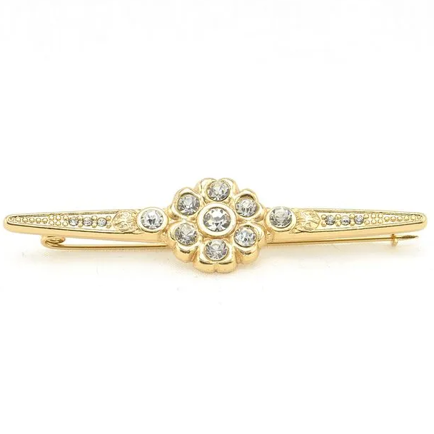 Gold brooch with gemstones on a white background